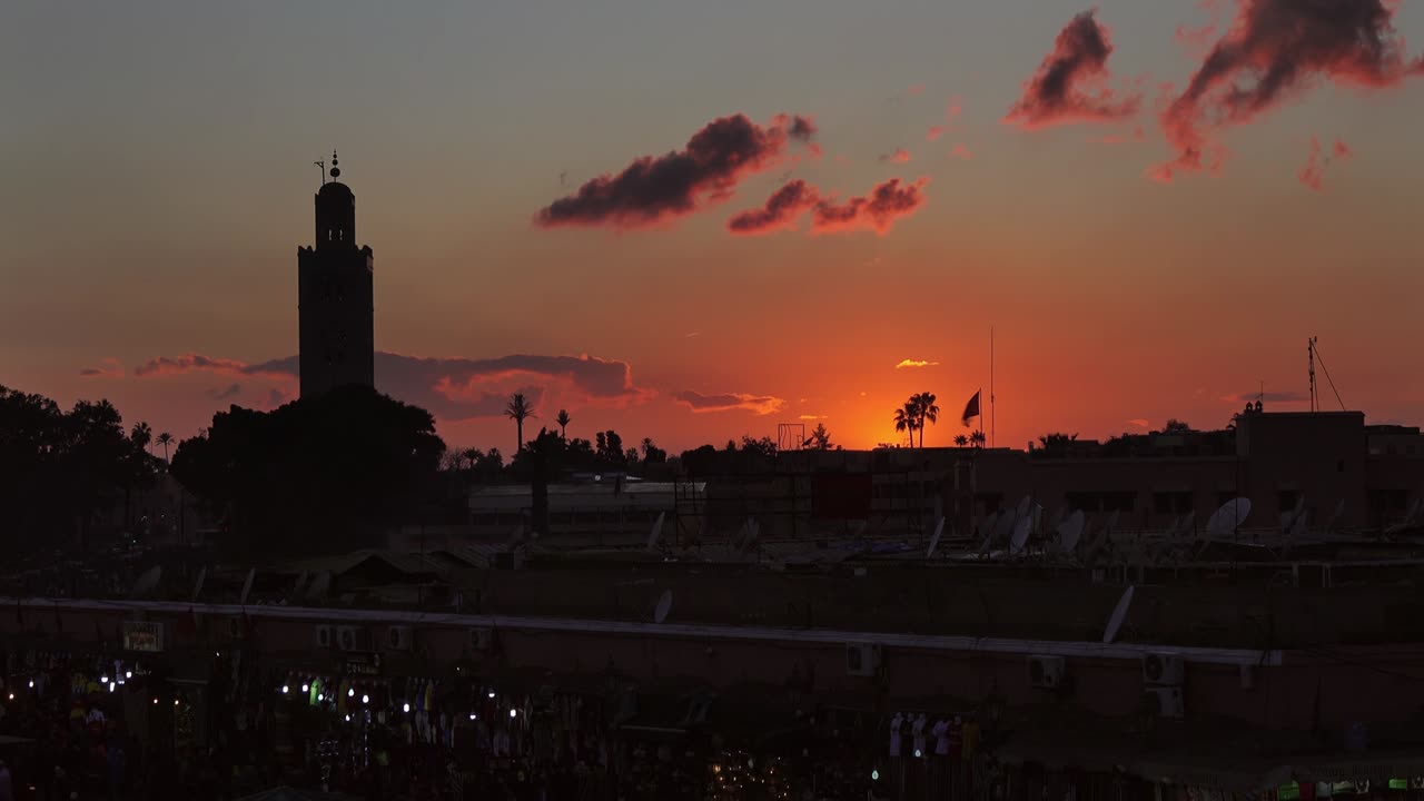 la plaza jemaa el fna está llena de gente al atardecer, en marrakech.