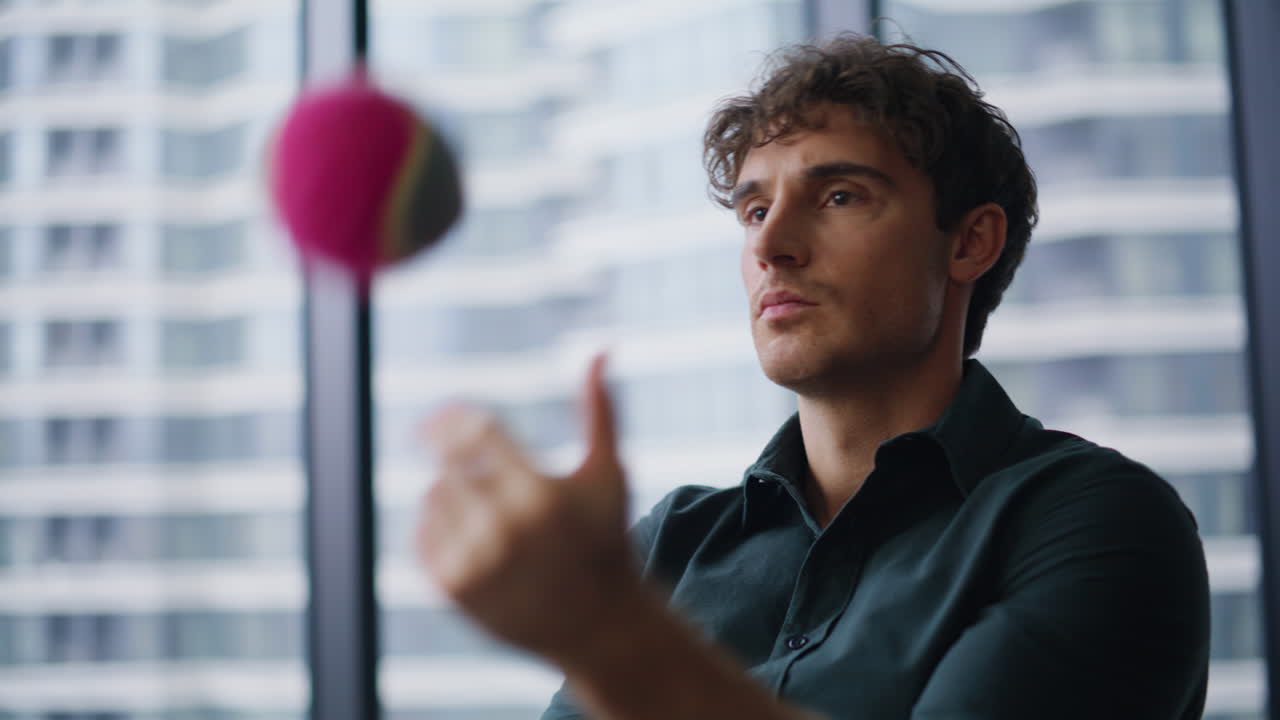 Serious leader thinking ideas throwing ball in office closeup. Focused executive