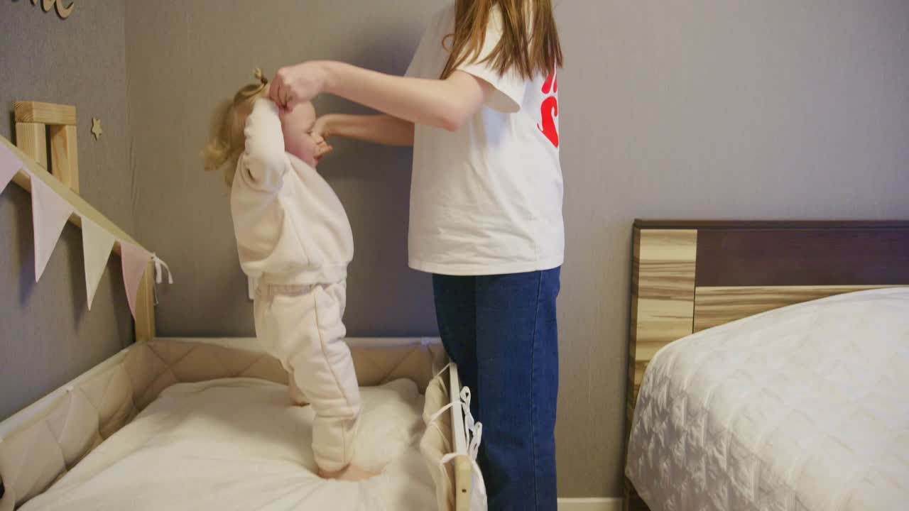 Mother Helps Baby Stand Up in Crib