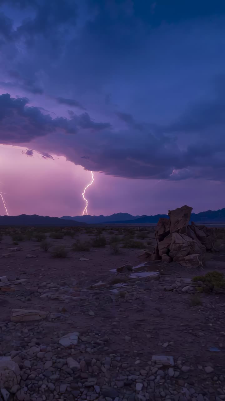 Vertical video: Shelf cloud sparking forked bolt striking and lighting dusk desert plain, outcrop