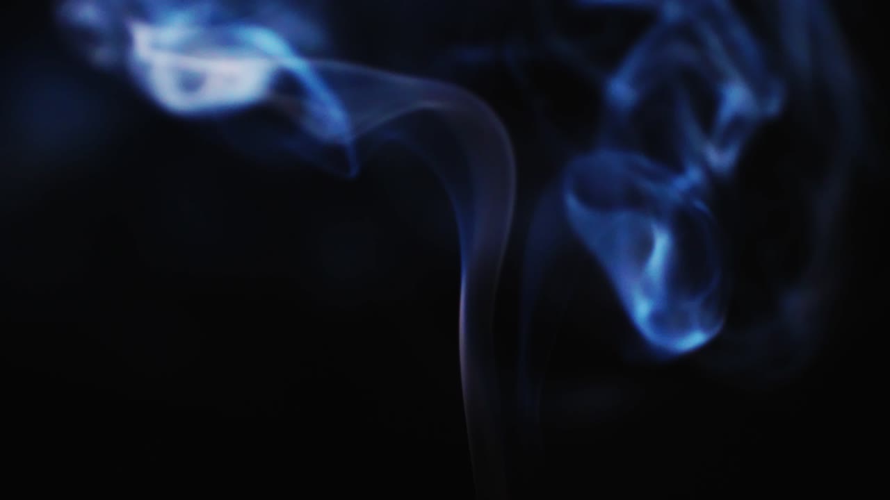 Fumo astratto di colore blu su sfondo nero al rallentatore.