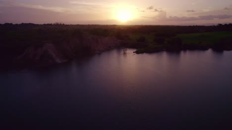 Drone-Volando-Sobre-Un-Lago-Revelando-La-Puesta-De-Sol