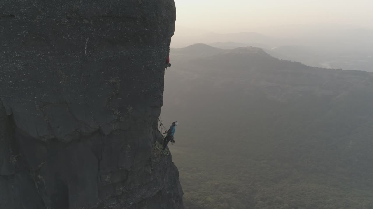인도 사야드리 산맥의 현무암 정상에서 다중 피치 스포츠 루트를 등반하는 암벽 등반가들의 영화적 드론 샷