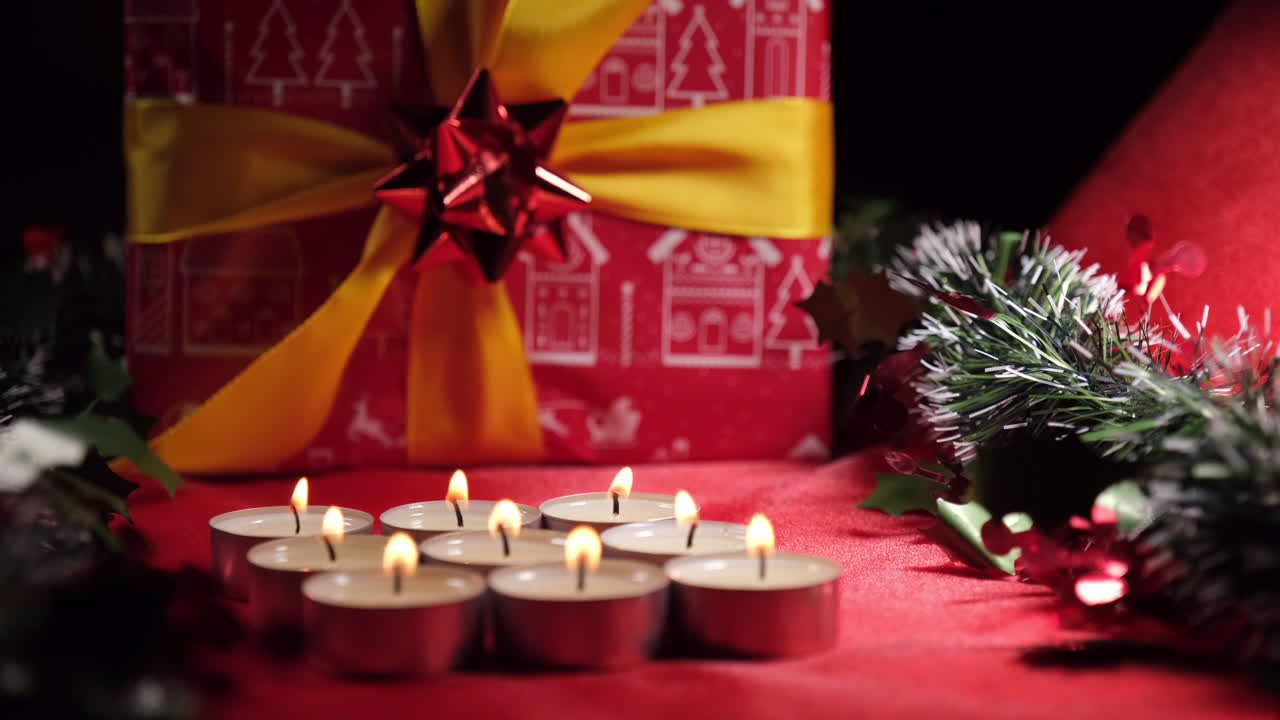 decoración navideña con velas y regalos sobre fondo rojo