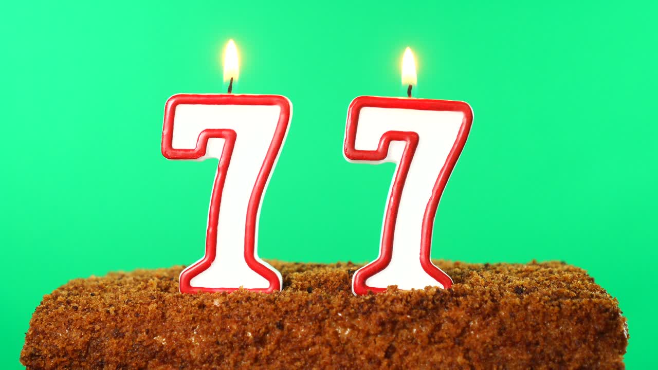 Cake with the number 77 lighted candle. Chroma key. Green Screen. Isolated