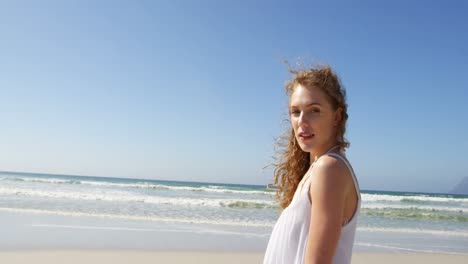 Woman-standing-at-beach-on-a-sunny-day-4k