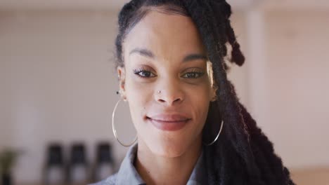 Portrait-of-happy-biracial-woman-looking-at-camera-in-dance-studio,-slow-motion