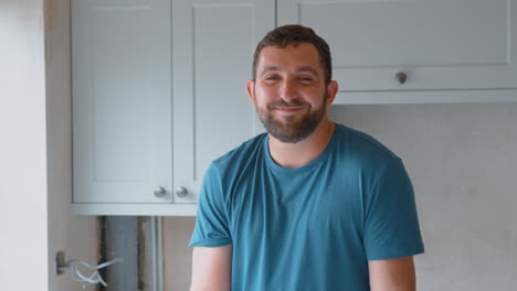 Retrato-De-Un-Hombre-Sonriente-Trabajando-En-La-Renovación-De-La-Cocina-En-Casa