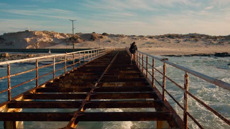 tourist-walking-on-bridge-above-lagoon-in-Marsa-Matrouh-reaching-Cleopatra-beach-in-Egypt