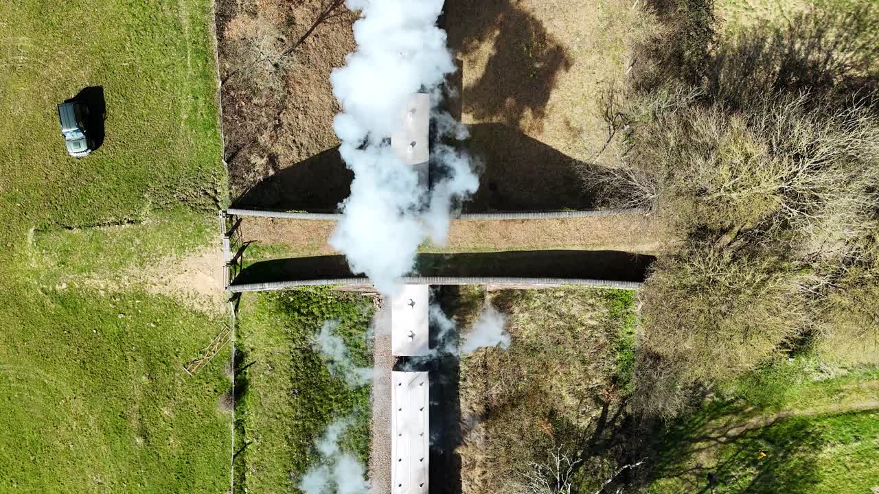 Experience breathtaking birds eye footage of a steam train chugging below a scenic bridge, steam billowing dramatically. Perfect for cinematic projects, travel films and nostalgic storytelling.
