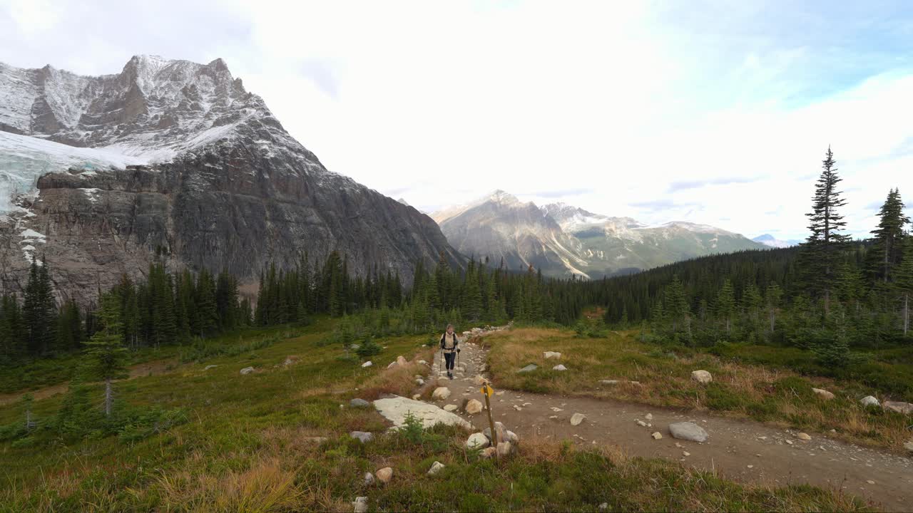 una mujer nórdica sola caminando por el sendero del valle en el parque nacional de jasper.