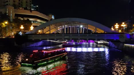 elgin bridge in singapore at night with two bumboat and night lights of sportsmen during singapore bicentennial