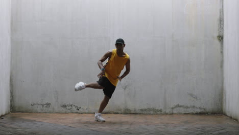 Hombre-Bailando-Joven-Feliz-Bailarín-Callejero-Realizando-Varios-Movimientos-De-Baile-De-Estilo-Libre-En-Forma-De-Hombre-De-Raza-Mixta-Practicando-En-Un-Almacén-Sucio-Con-Chaleco-Amarillo