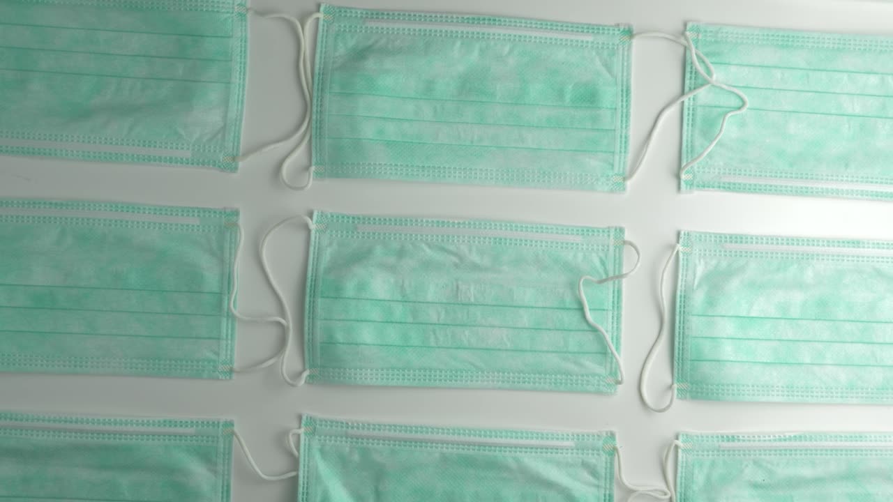 máscaras faciales desechables dispuestas en un patrón - toma de cabeza giratoria