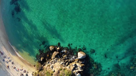 Vista-Aérea-Sobre-Una-Playa-Y-Mar-Turquesa-Y-Poco-Profundo,-En-Cabo-San-Juan-Del-Guia-En-Tairona,-Colombia---De-Arriba-Hacia-Abajo,-Disparo-De-Drones