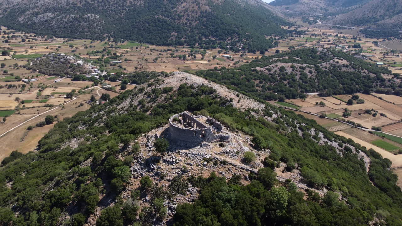 Antica rovina in cima a una montagna in un clima caldo, ripresa in avvicinamento aereo.