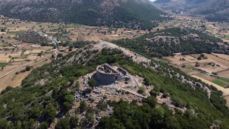 Ruina-Antigua-En-La-Cima-De-La-Montaña-En-Un-Clima-Cálido,-Enfoque-Aéreo