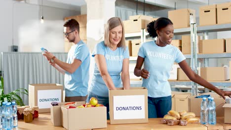 multiethnic group of volunteers in facial mask packing boxes with food in charity warehouse