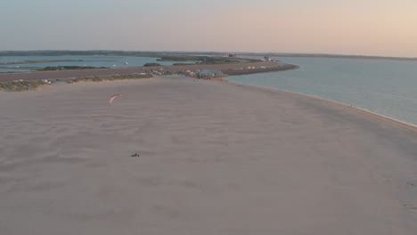 drone cinemático - toma aérea de la playa de arena natural al atardecer con buggykiting en zelanda en el mar del norte, países bajos, 25p