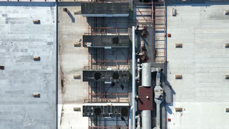 industrial building rooftop with hvac ventilation and air conditioning units along with pipes