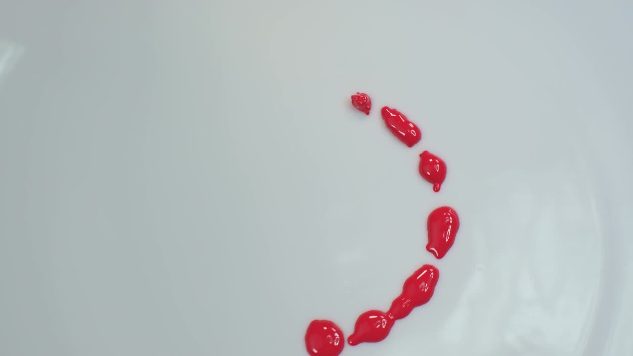 A red circle drips onto a spinning white background.