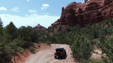 Drone-shot-following-a-4x4-driving-on-a-rough-road,-sunny-day-in-Arizona,-USA