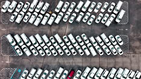 coches de policía sin marcas en un gran estacionamiento aéreo disparado directamente hacia abajo volando rápidamente