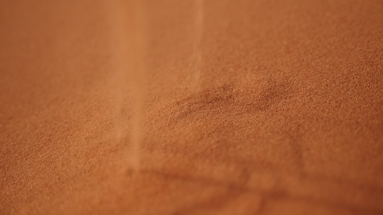 Desert sand rises in reverse slow motion, symbolizing time moving back