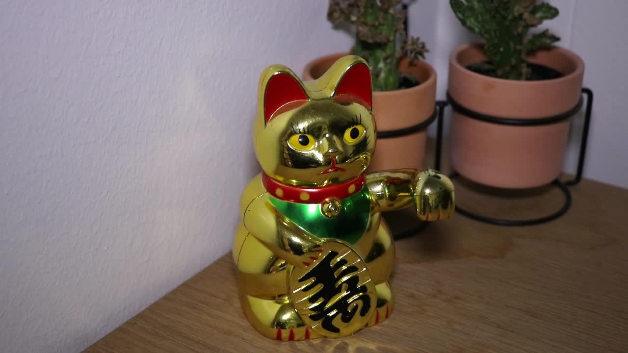 Golden "Maneki-neko" waving on desk