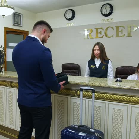 modern luxury hotel reception. young man on business trip doing check in at the hotel