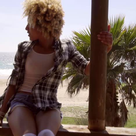 mujer joven sentada en un balcón frente al mar