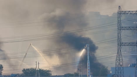 Static-shot-of-multiple-firefighter-crews-tackling-a-large-blaze-at-a-chemical-plant