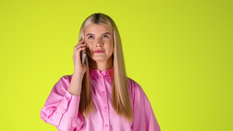 Junge-Blonde-Frau-Telefoniert,-Lächelt-Und-Lacht,-Studioaufnahme-Mit-Grün-gelbem-Hintergrund