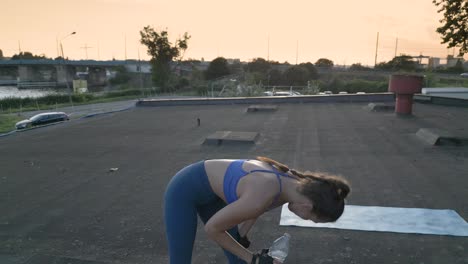 fit woman takes a break from her workout to drink some water