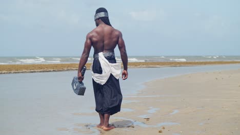 a muscular, dark-skinned man embodies nekharis cosplay with perfection on a tropical beach