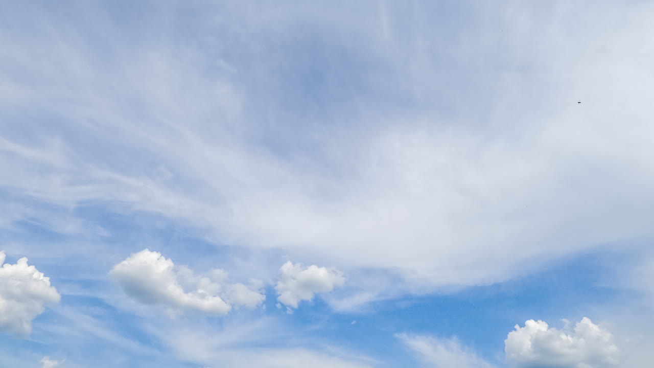 Amazing light spindrift clouds covering the sky. Soft puffy little clouds flying past. Low angle timelapse.