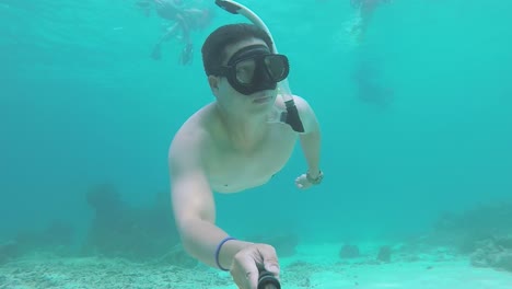Hombre-Buceando-Y-Nadando-Bajo-El-Agua-Entre-Las-Tomas-De-Coral-Selfie