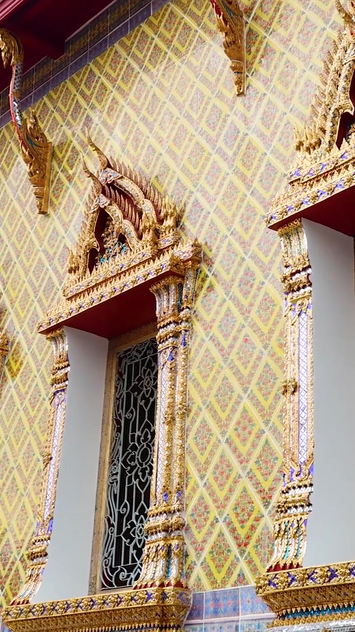 Una vista detallada de la intrincada fachada del templo Wat Pho, mostrando la arquitectura tradicional tailandesa con colores vibrantes y diseños ornamentados.