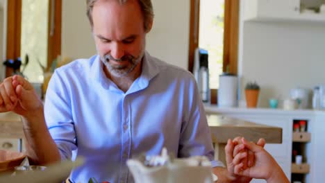 Family-praying-together-before-having-breakfast-in-kitchen-4k