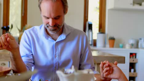 familia orando juntos antes de desayunar en la cocina 4k