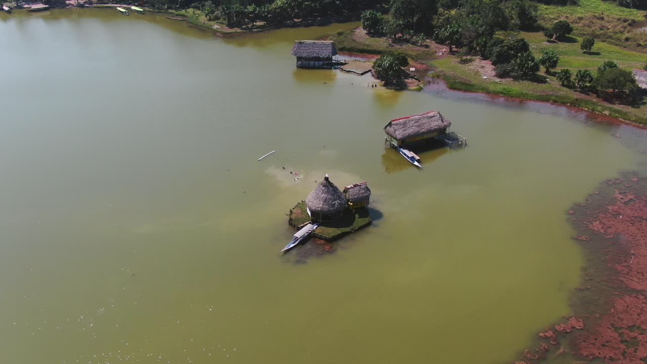 4k 주간 공중 드론 전망은 페루 라구나 데 로스 밀라그로스, 팅고 마리아에 있는 호수 위의 작은 집을 내다보고 있습니다.