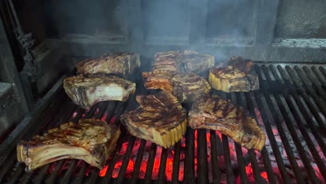 grandes filetes de carne gruesa cocinar en una parrilla de barbacoa caliente sobre carbón de brasa roja