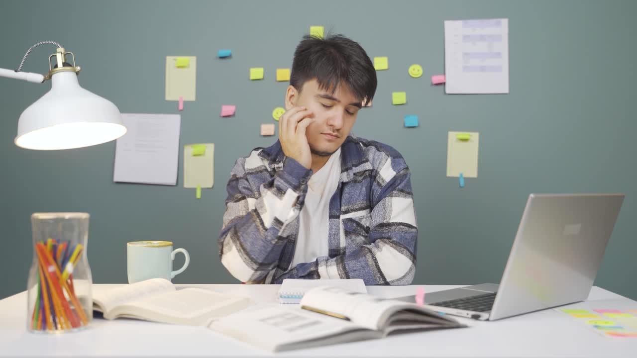 勉強中に居眠りする男子学生