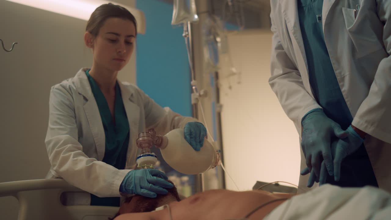 медсестра помогает в процессе сердечного массажа в больничном отделении. сотрудники клиники спасают жизни
