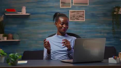 Smiling-african-american-freelancer-listening-music-at-laptop