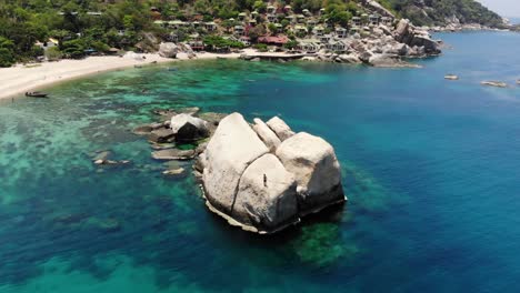 chico salta de una gran roca al mar, playa de la bahía de tanote, koh tao, tailandia