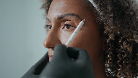 closeup cosmetologist marking botox injection site. woman visiting beauty salon