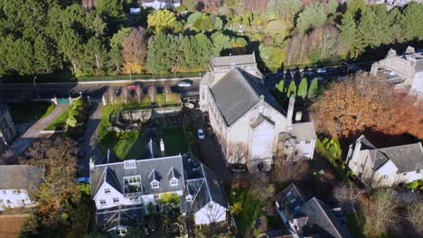 aerial view of a stone church and residential area in scotland