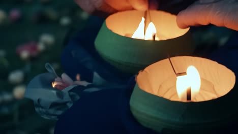 primer plano de manos encendiendo velas durante una ceremonia religiosa