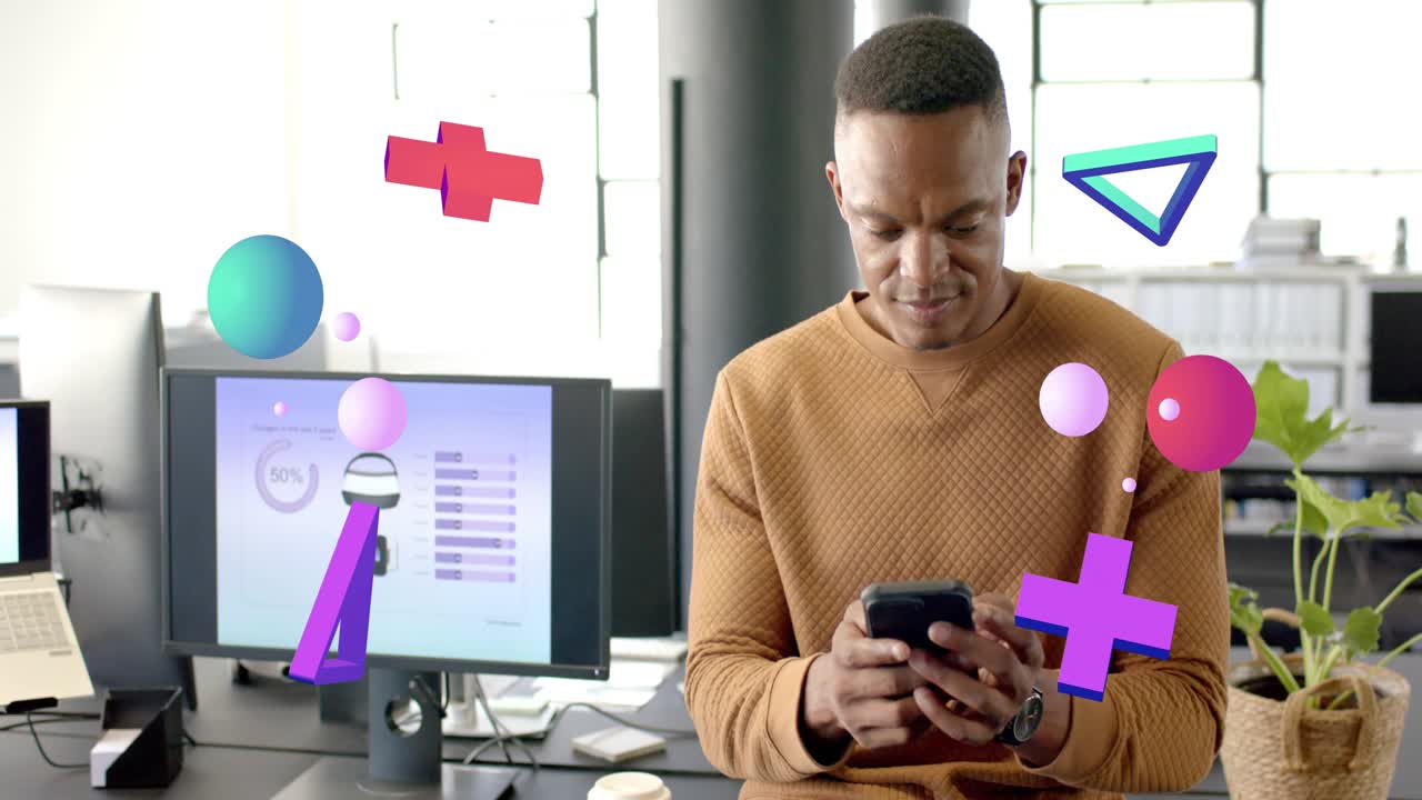 Man sitting at desk tapping phone, viewing dashboard, smiling, making 3D shapes floating around him